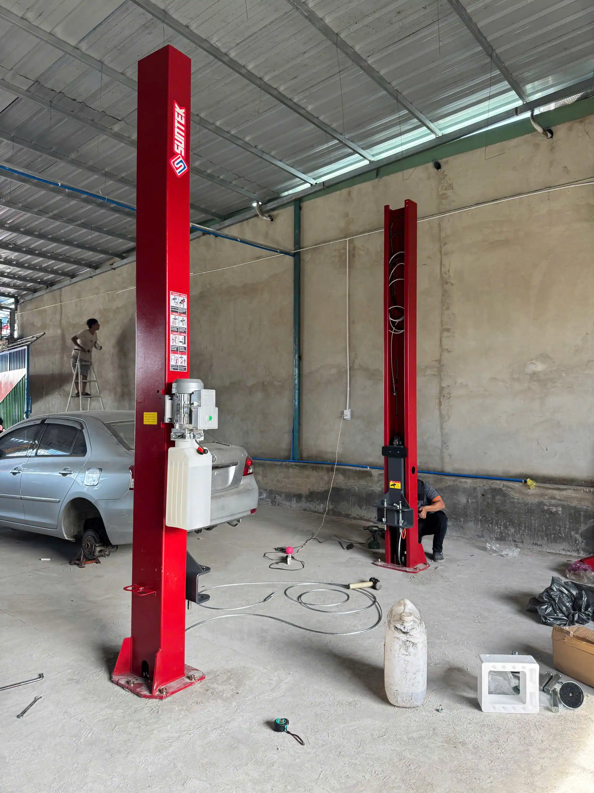 Cầu nâng lắp đặt trong gara sửa chữa xe sedan