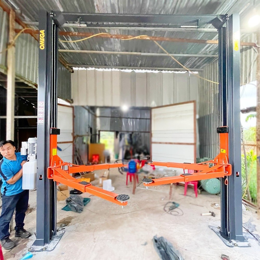Cầu nâng ô tô 2 trụ giằng trên OMEGA OM-40H 4 tấn lắp đặt thực tế tại xưởng, tay nâng màu cam
