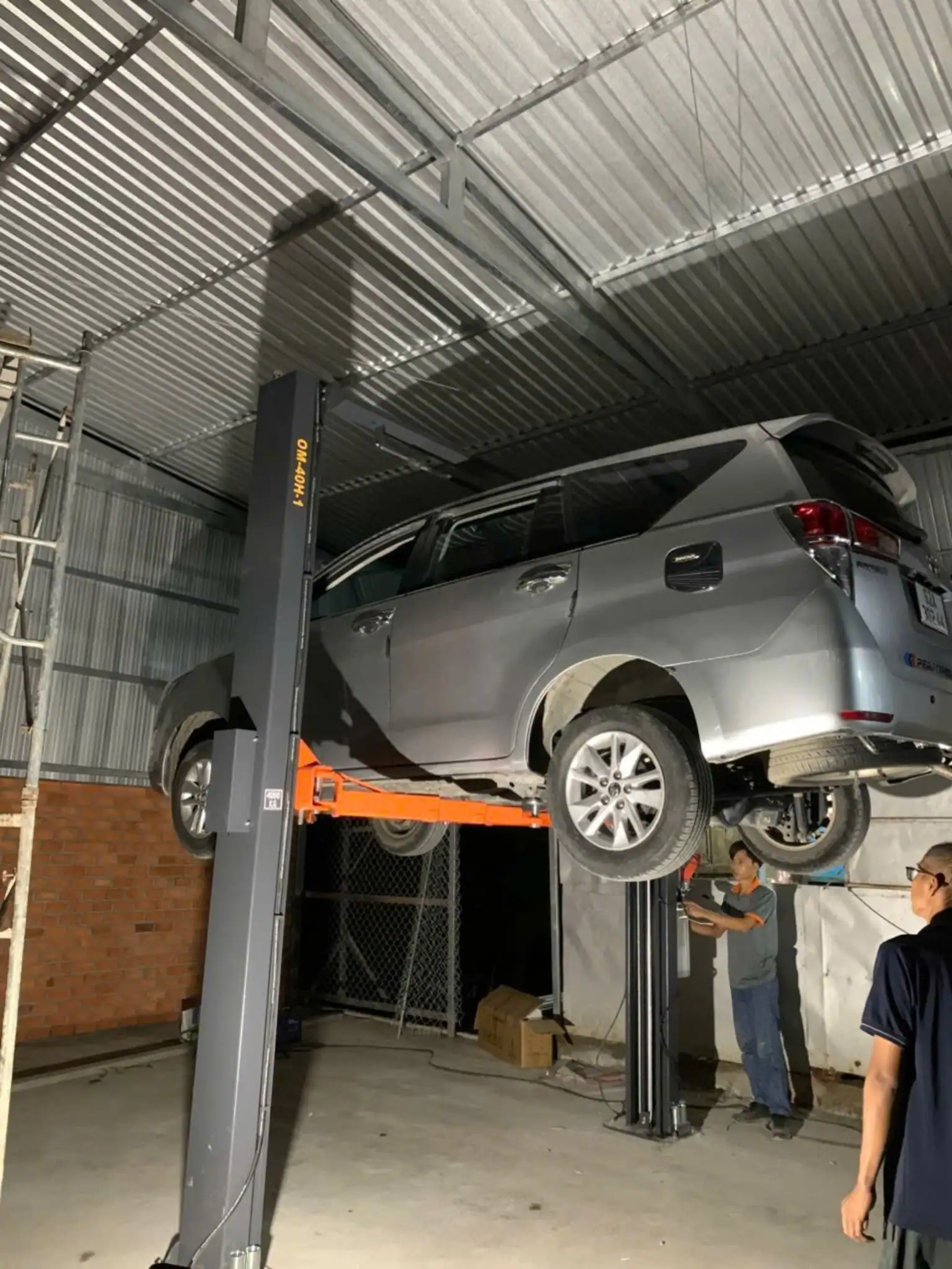 Xe ô tô nâng cao trên cầu nâng 2 trụ giằng trên OMEGA OM-40H-1 4 tấn – góc nhìn bên hông