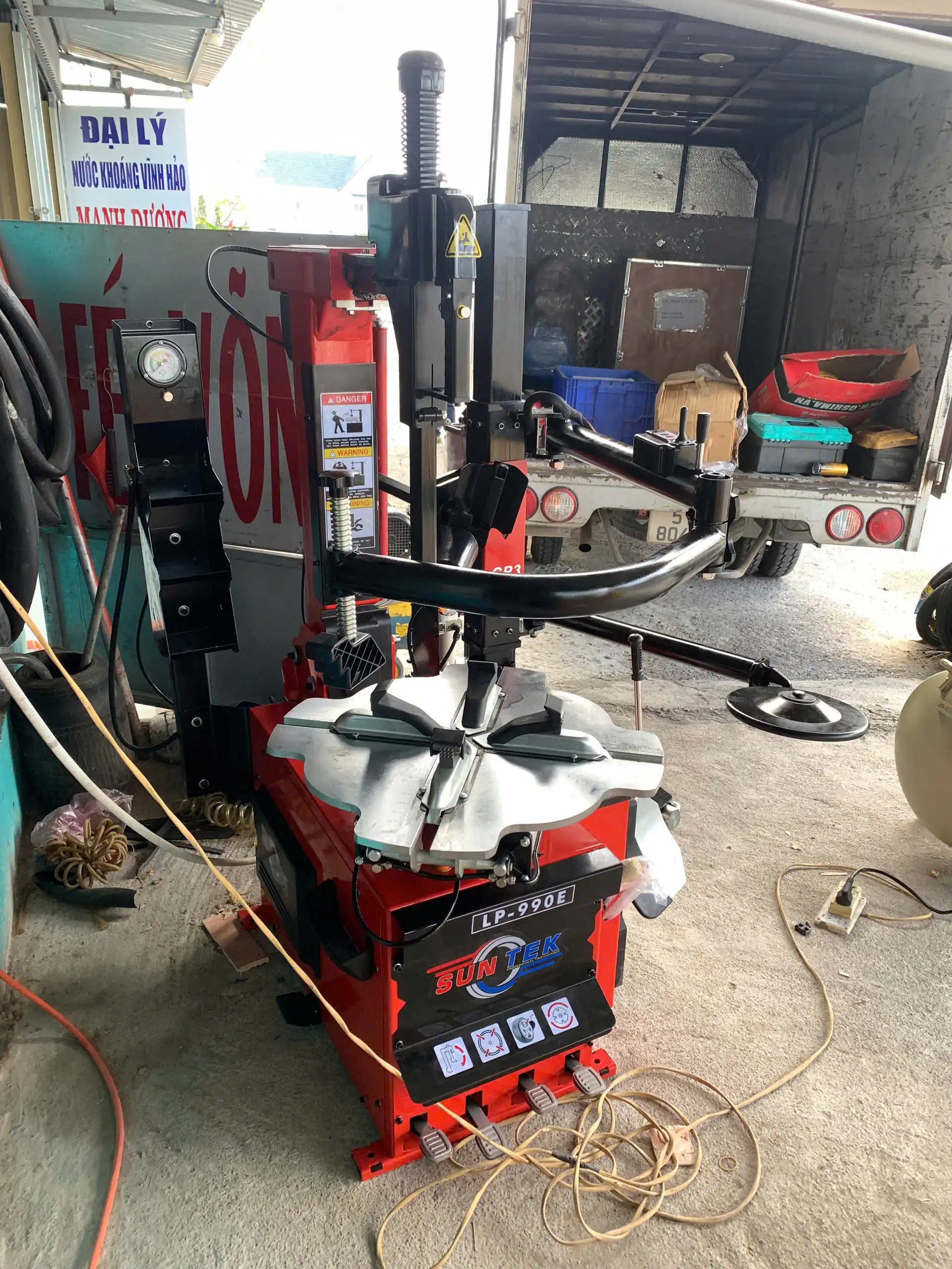 Kỹ thuật viên hướng dẫn vận hành máy tháo lốp SunTek LP-990E cho anh Hòa tại Bình Thuận