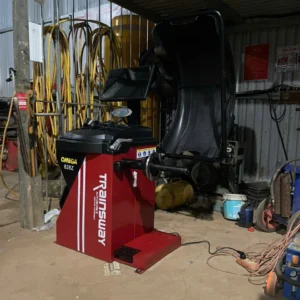 Máy cân mâm Omega 828Z Trainsway đỏ đặt trong gara sửa chữa ô tô.