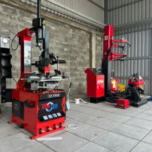 Máy tháo vỏ xe du lịch SunTek LP-990E và máy nén khí trong một gara sửa chữa xe chuyên nghiệp.