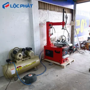 Máy nén khí LOPATEK 3HP – 100L – 8Bar hoạt động cùng máy ra vào lốp tại tiệm sửa chữa xe.